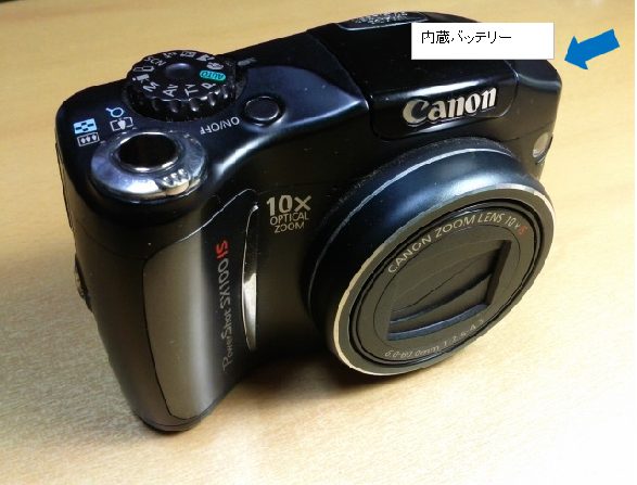 Canon Power Shot SX100IS の全体写真と内蔵バッテリーの位置表示